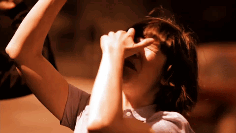 A Person Covering Their Face With Their Hand While Looking Up GIF