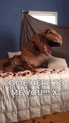 A Person Dressed As A T-Rex Is Sitting On A Bed With Roses On It . GIF