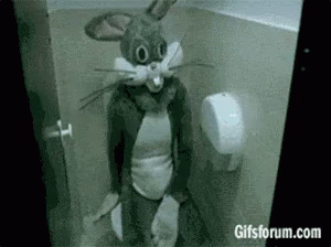 A Person Dressed As Bugs Bunny Is Sitting In A Toilet . GIF
