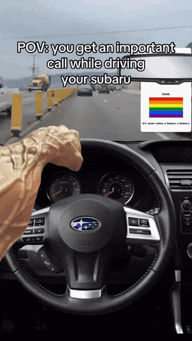 A Person Driving A Subaru With A Rainbow Flag On The Dashboard GIF