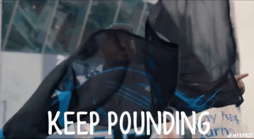 A Person Holding A Black Cloth That Says " Keep Pounding " GIF