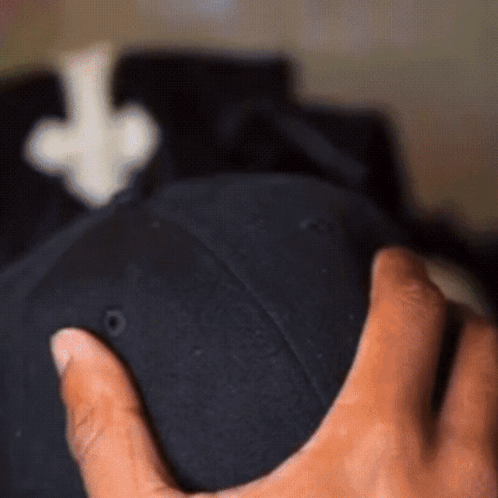 A Person Holding A Black Hat With An Arrow Pointing Up GIF