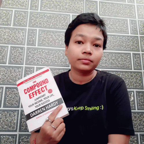 A Person Holding A Book Titled Compound Effect By Darren Hardy GIF