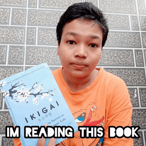 A Person Holding A Book Titled Ikigai And Says I 'M Reading This Book GIF
