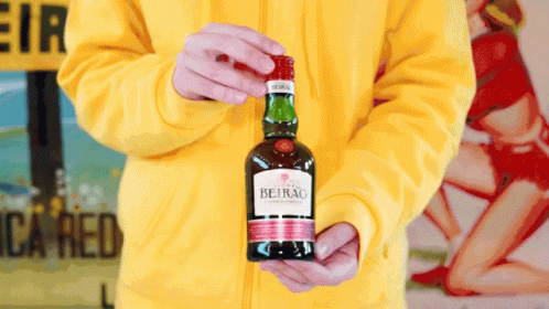 a person holding a bottle of beirao in their hands