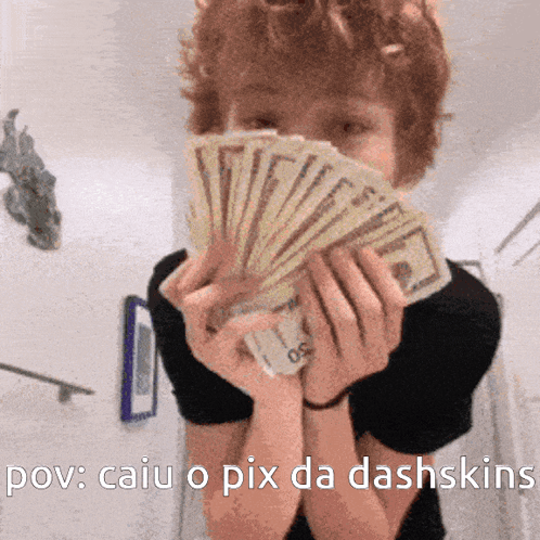 A Person Holding A Bunch Of Money In Front Of Their Face GIF