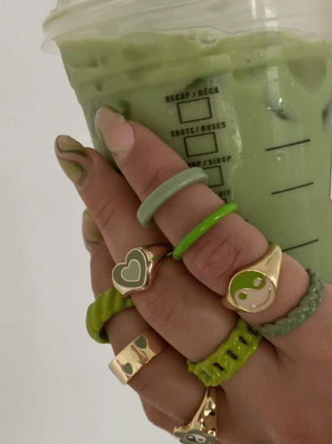 A Person Holding A Cup Of Green Liquid That Says Decaf / Deca GIF