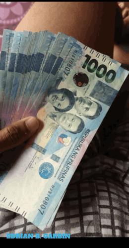 A Person Holding A Fan Of 1000 Peso Bills GIF