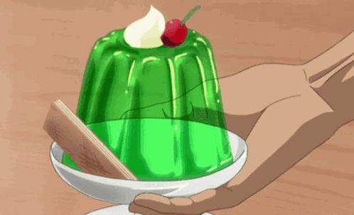 A Person Holding A Green Dessert With A Cherry On Top GIF