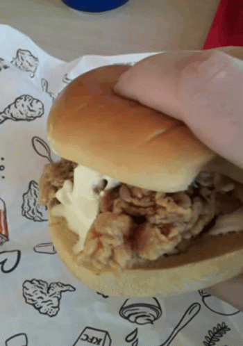 A Person Holding A Kfc Chicken Sandwich On A Bun GIF