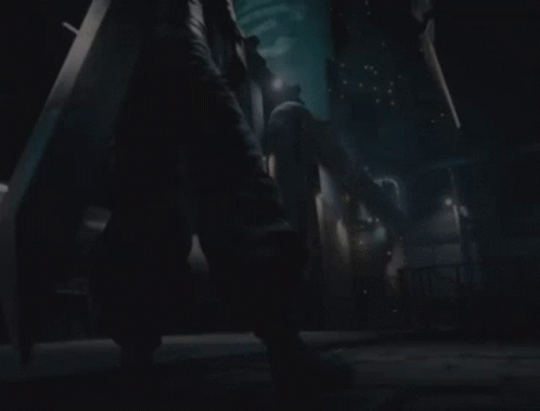 A Person Holding A Large Sword Standing In A Dark Room GIF