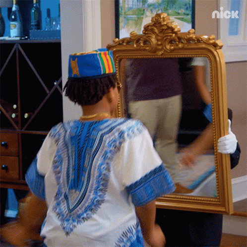 A Person Holding A Mirror With A Nick Logo On The Bottom Left GIF