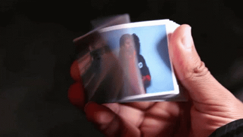 A Person Holding A Piece Of Paper With A Picture Of A Woman On It GIF