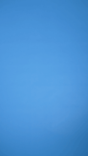 A Person Holding A Red Balloon Against A Blue Sky GIF