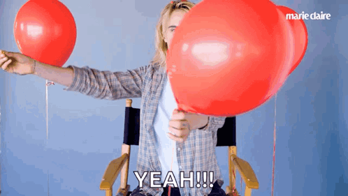 A Person Holding A Red Balloon With The Word Yeah Written On It GIF