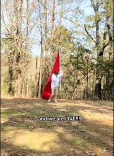 A Person Holding A Red Flag With The Words And We Are Live Written On The Bottom GIF