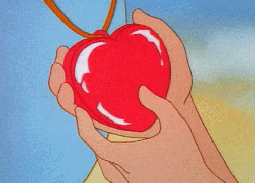 A Person Holding A Red Heart Shaped Object GIF