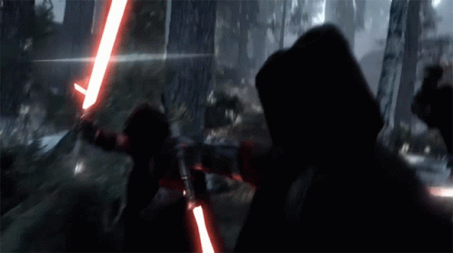 A Person Holding A Red Light Saber In The Dark GIF