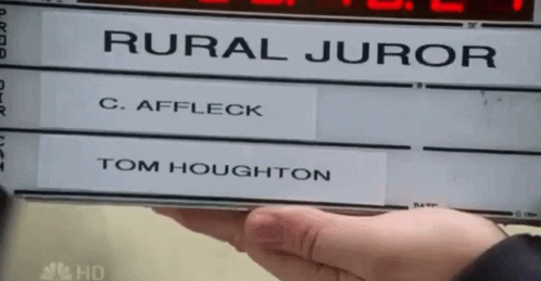 A Person Holding A Sign That Says Rural Juror And Tom Houghton GIF