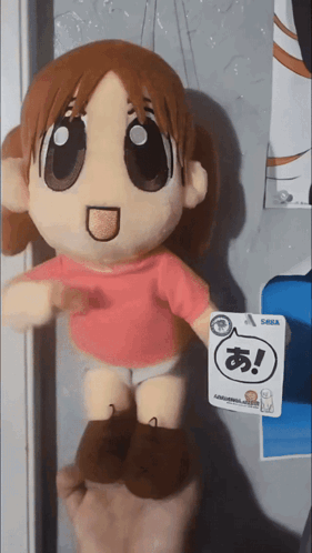 A Person Holding A Stuffed Doll With A Tag That Says Sega GIF