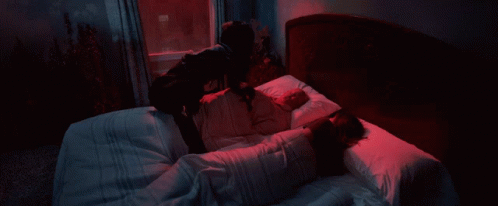 A Person Holding A Sword In Front Of A Window With A Blue Curtain GIF