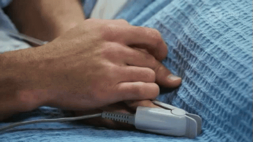 A Person Holding Another Person 'S Hand With A Pulse Oximeter Attached To It GIF