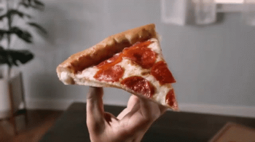 A Person Holds A Slice Of Pepperoni Pizza In Their Hand GIF