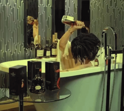 A Person In A Bathtub Pouring A Bottle Of Hennessy GIF
