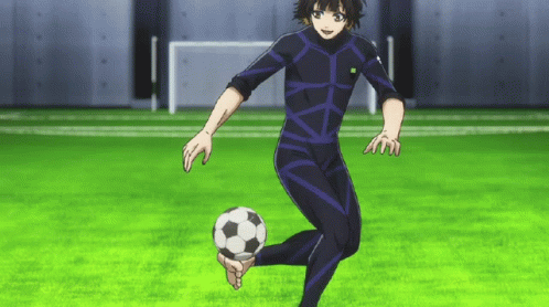 a person in a black suit kicking a soccer ball on a field