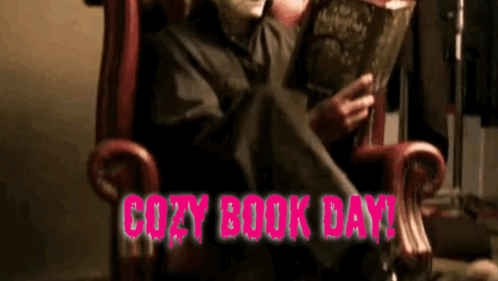 A Person In A Chair Reading A Book With The Words Cozy Book Day In Pink GIF