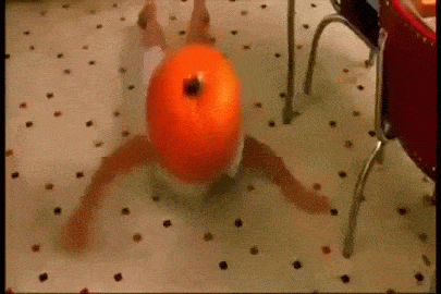 A Person In A Diaper Is Laying On The Floor With A Pumpkin On Their Head . GIF