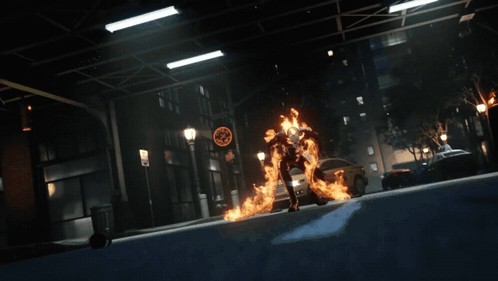 A Person In A Fire Suit Is Standing On A Street GIF