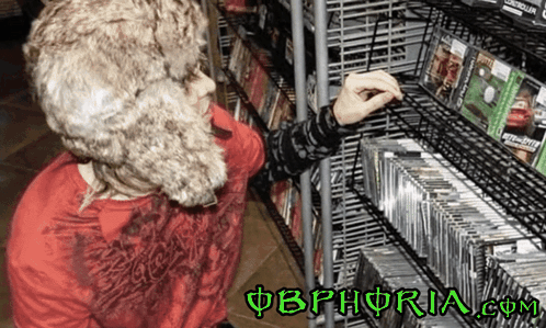 A Person In A Fur Hat Is Looking At Cds On A Shelf With The Website Obphoria.com In The Corner GIF