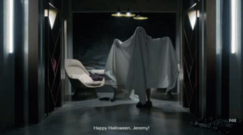 A Person In A Ghost Costume Says " Happy Halloween Jeremy " In A Dark Hallway GIF