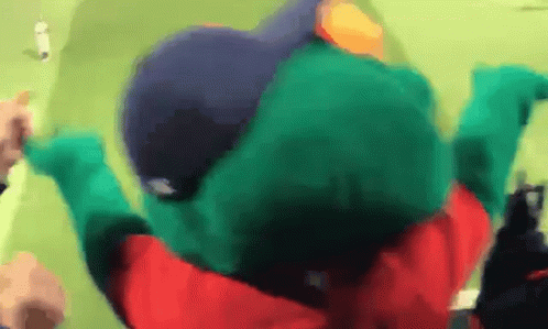 A Person In A Green Frog Costume Is Laying On The Ground GIF