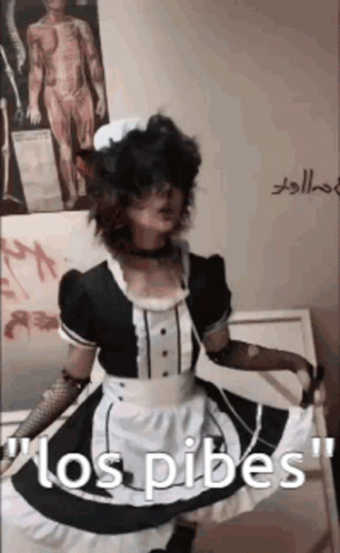 A Person In A Maid Costume Is Standing In Front Of A Wall With A Picture Of A Man On It . GIF
