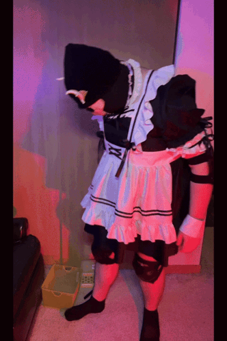 A Person In A Maid Costume Is Standing Next To A Yellow Box GIF