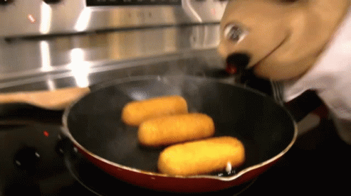 A Person In A Mickey Mouse Costume Is Cooking Food In A Frying Pan GIF
