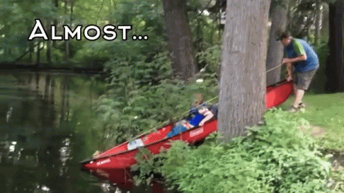 A Person In A Red Kayak Is Being Pulled Out Of The Water By A Tree With The Words " Almost " Above It GIF