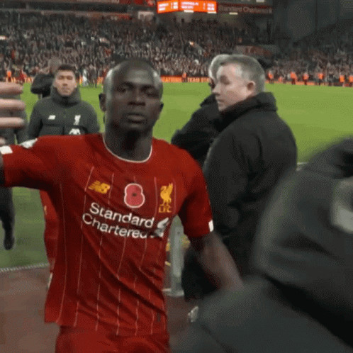 A Person In A Red Shirt Is Standing In Front Of A Red Wall . GIF