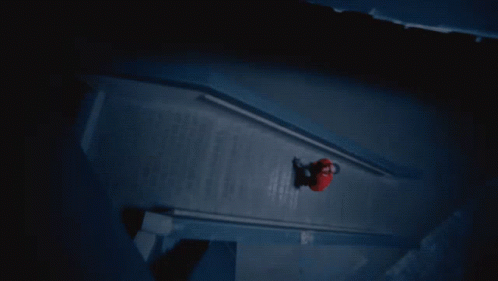 A Person In A Red Shirt Is Walking Down A Dark Staircase GIF