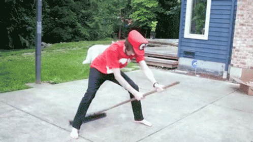 A Person In A Red Shirt With The Letter C On It Is Holding A Broom GIF