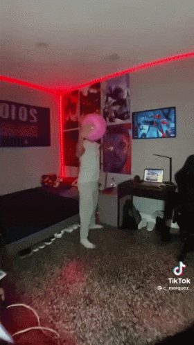 A Person In A Room With A Pink Balloon On Their Head And A Sign That Says Solo GIF