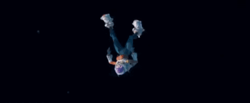A Person In A Space Suit Is Falling Through The Air In The Dark . GIF