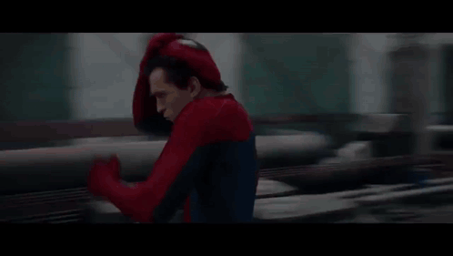 A Person In A Spider-Man Costume Is Running On A Bridge . GIF