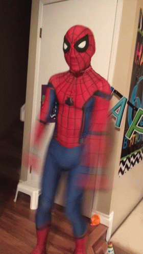 A Person In A Spider Man Costume Is Standing In Front Of A Birthday Banner GIF