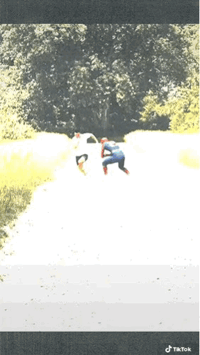 A Person In A Spiderman Costume Is Walking Down A Path GIF