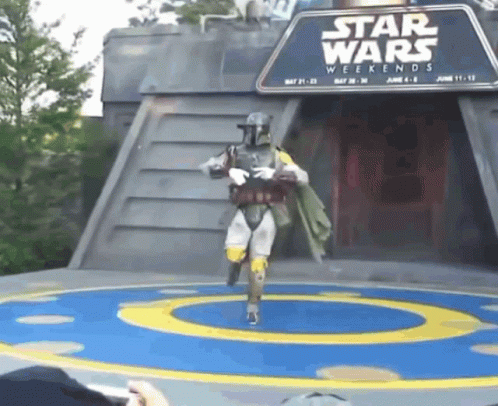 A Person In A Star Wars Costume Is Dancing In Front Of A Star Wars Weekends Sign GIF