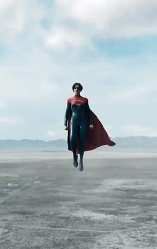 A Person In A Superman Costume Is Flying Through The Air GIF