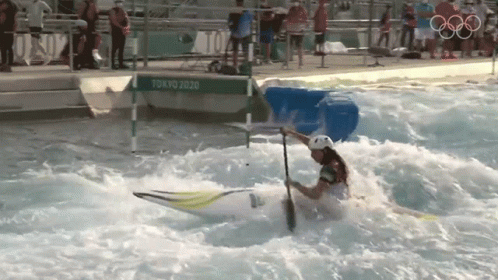 A Person In A White Helmet Is Paddling A Kayak In A Pool With A Sign That Says Tokyo 2020 GIF
